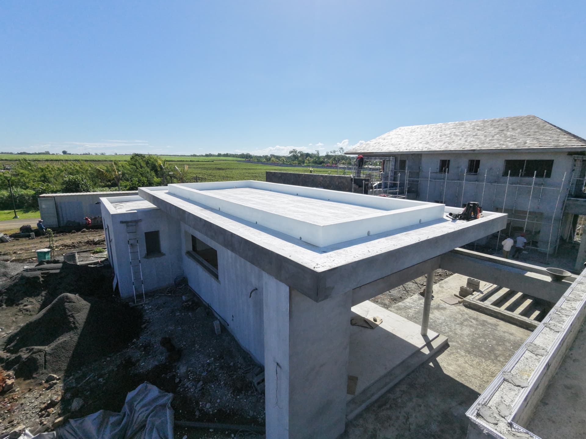 Vue aérienne d'un chantier avec toiture plate en béton et étanchéité blanche