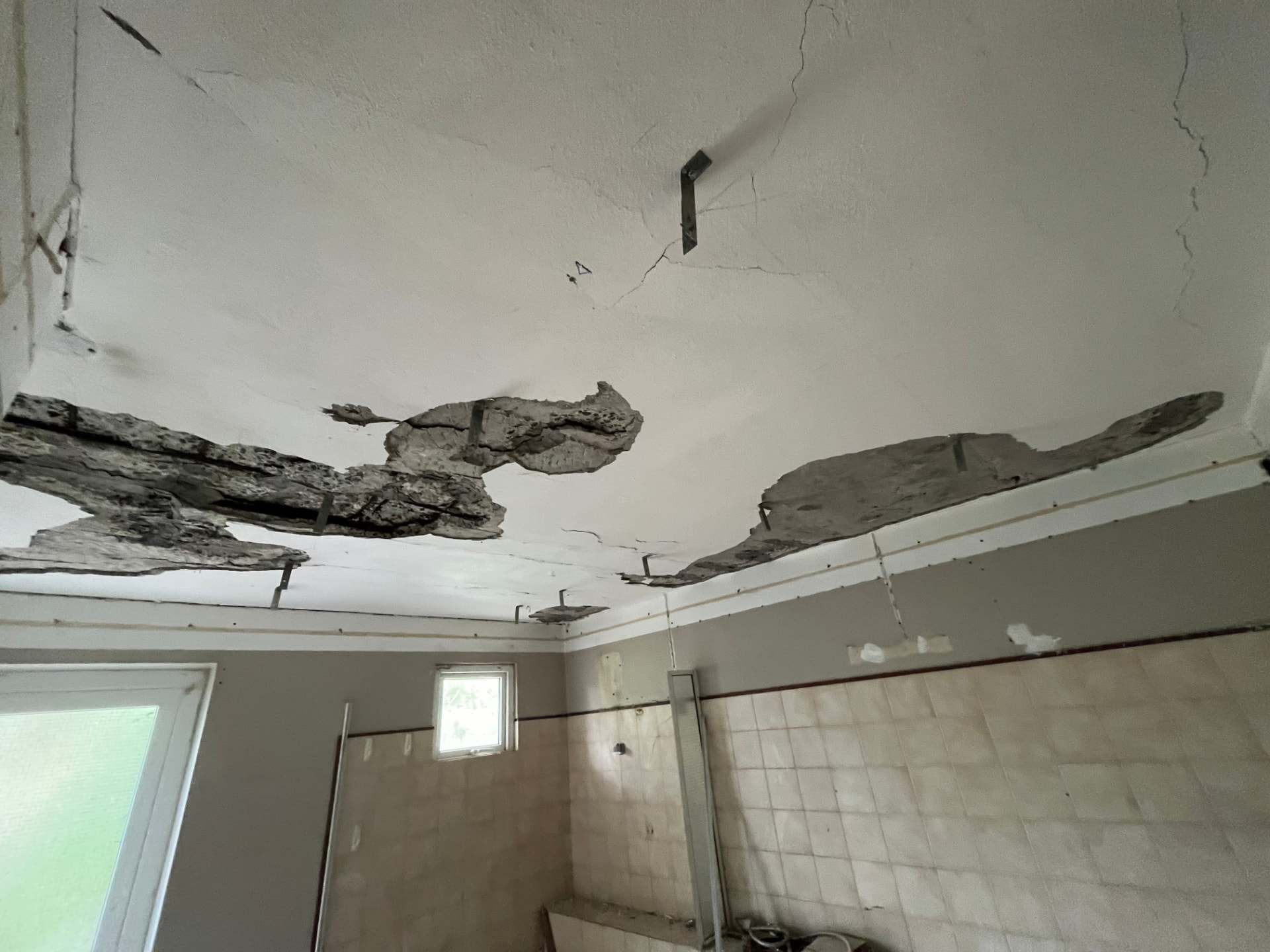 Plafond en béton éclaté par une infiltration prolongée
