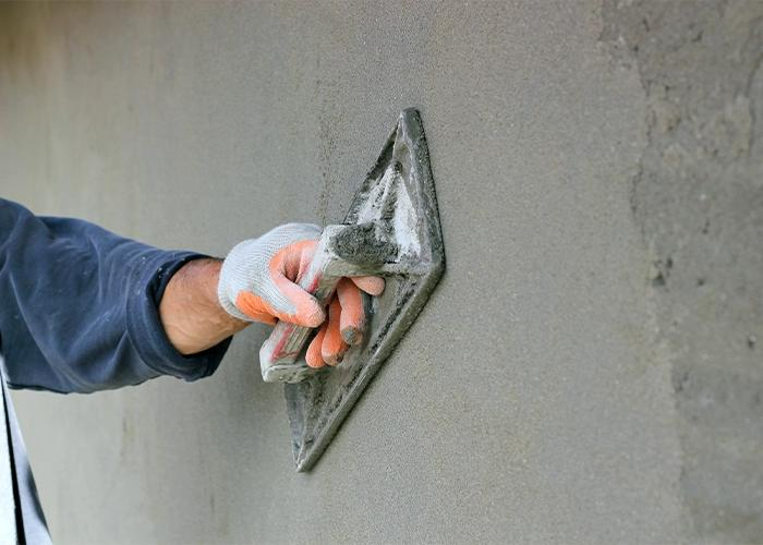 Application d'un crépi sur un mur de maçonnerie